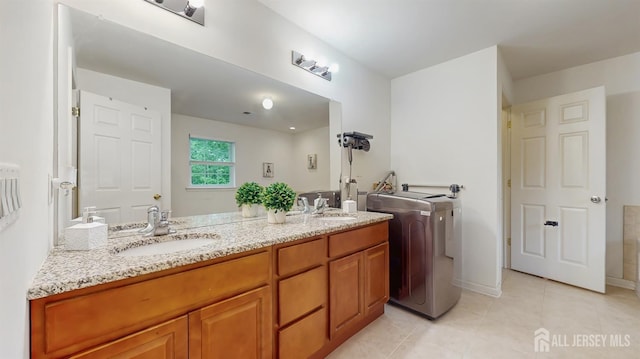 612 Magnolia Rd, North Brunswick, NJ 08902 - bathroom featuring tile patterned flooring, washer / clothes dryer, double vanity, and baseboards