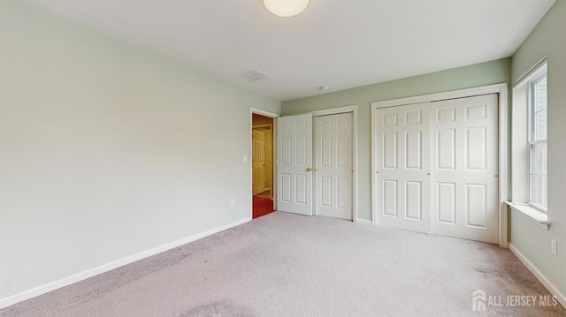 612 Magnolia Rd, North Brunswick, NJ 08902 - unfurnished bedroom with multiple closets, carpet flooring, and multiple windows