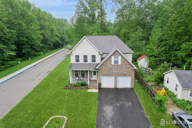 612 Magnolia Rd, North Brunswick, NJ 08902 - traditional-style house featuring a porch, stone siding, asphalt driveway, an attached garage, and a front lawn