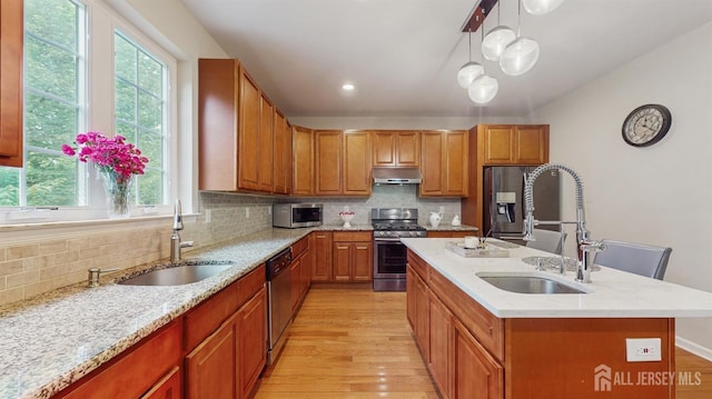612 Magnolia Rd, North Brunswick, NJ 08902 - kitchen with stainless steel appliances, a sink, under cabinet range hood, and light wood-style floors