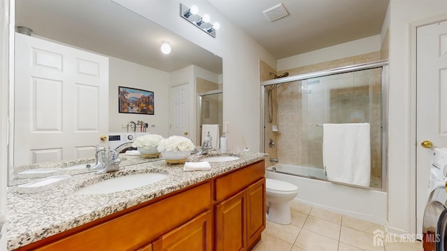 612 Magnolia Rd, North Brunswick, NJ 08902 - full bath with tile patterned flooring, double vanity, washer / clothes dryer, enclosed tub / shower combo, and toilet