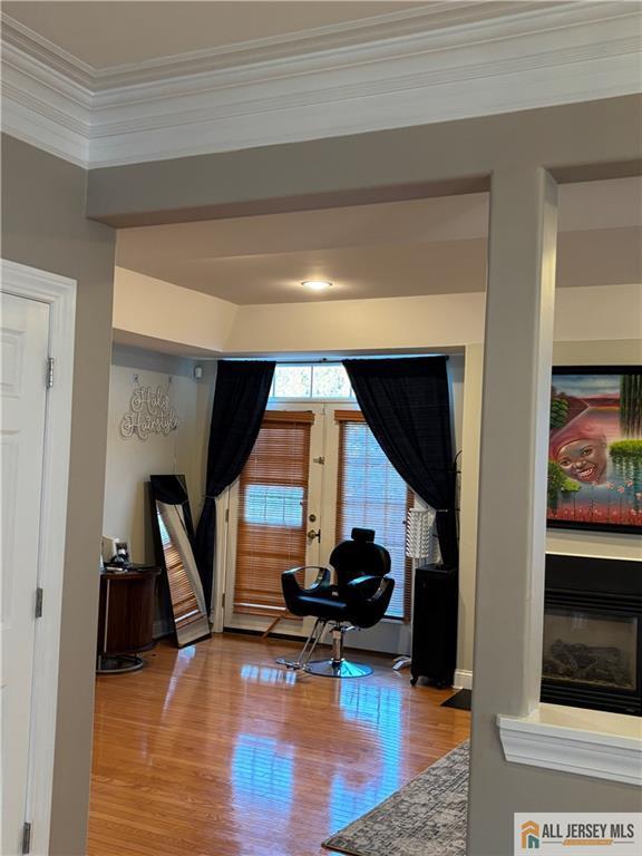 sitting room with french doors, wood finished floors, and ornamental molding