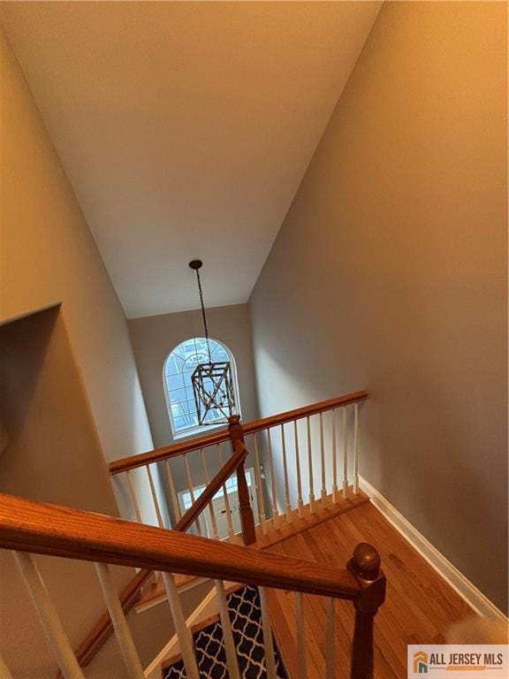 staircase featuring wood finished floors and baseboards