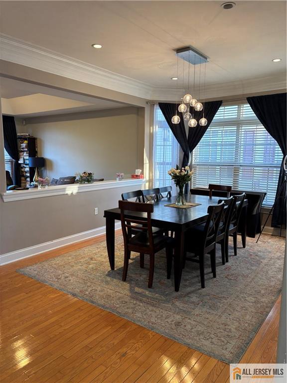 dining space featuring crown molding and hardwood / wood-style floors