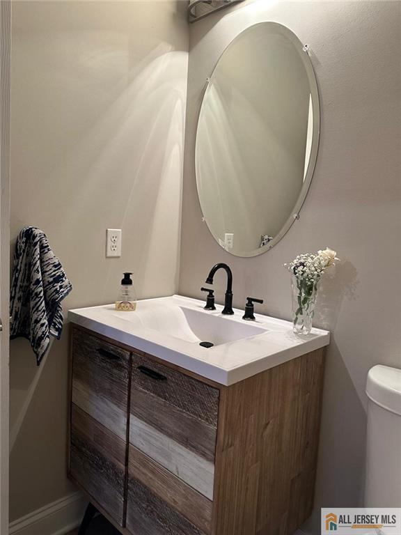 half bathroom featuring toilet and vanity