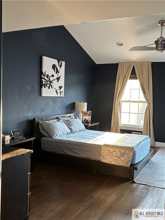 bedroom with wood finished floors, a ceiling fan, and lofted ceiling