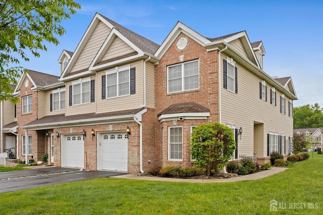 view of property featuring driveway, brick siding, a garage, and a front lawn