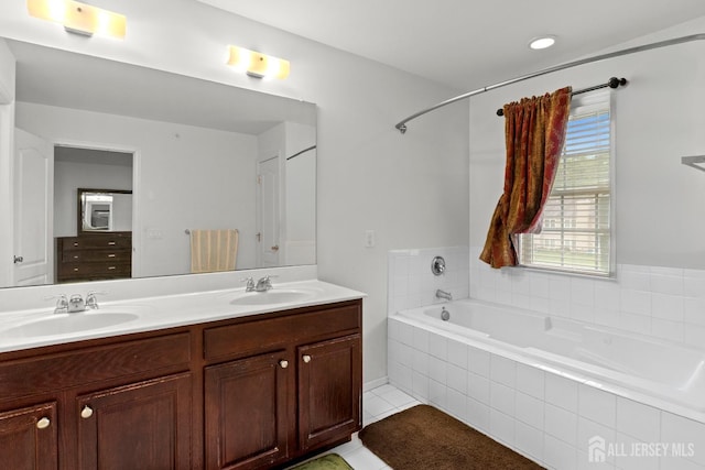 bathroom featuring tiled tub, tile patterned flooring, and double vanity