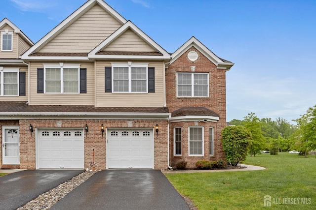 multi unit property with driveway, a front yard, a garage, and brick siding