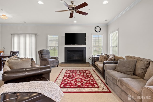 living room featuring crown molding, light colored carpet, a glass covered fireplace, a ceiling fan, and recessed lighting