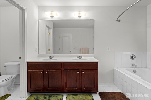 bathroom featuring a relaxing tiled tub, tile patterned floors, toilet, double vanity, and baseboards