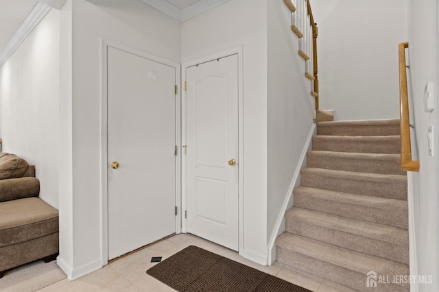 stairway with tile patterned flooring, baseboards, and crown molding
