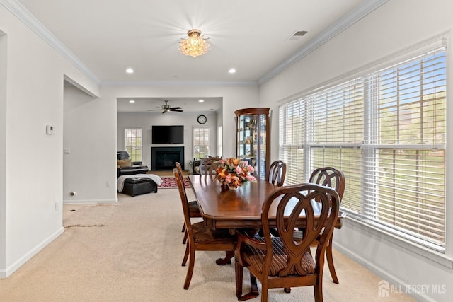 dining area featuring light colored carpet, baseboards, plenty of natural light, recessed lighting, and crown molding