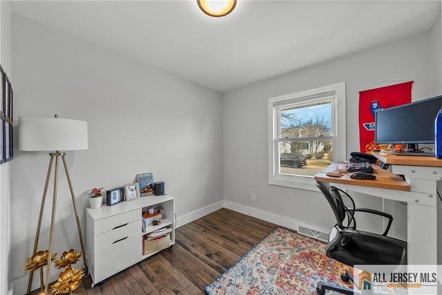 office area with visible vents, baseboards, and wood finished floors