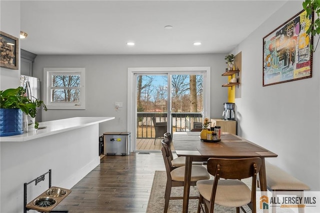 dining area featuring a healthy amount of sunlight, baseboards, dark wood-type flooring, and recessed lighting