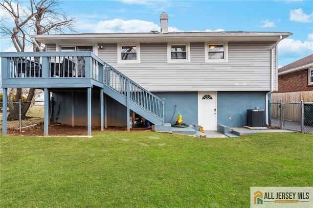 back of house featuring fence, stairway, and a yard