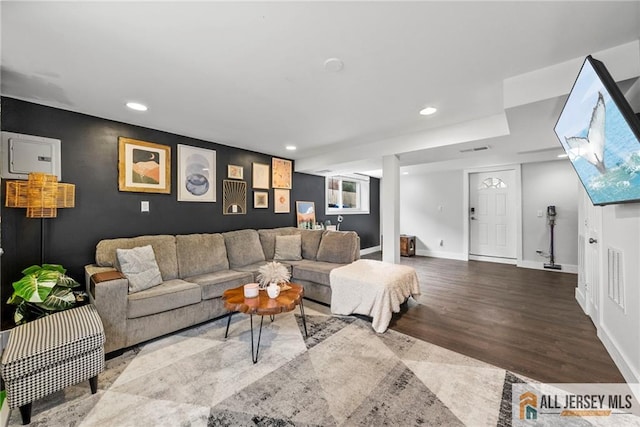 living area with recessed lighting, wood finished floors, visible vents, and baseboards