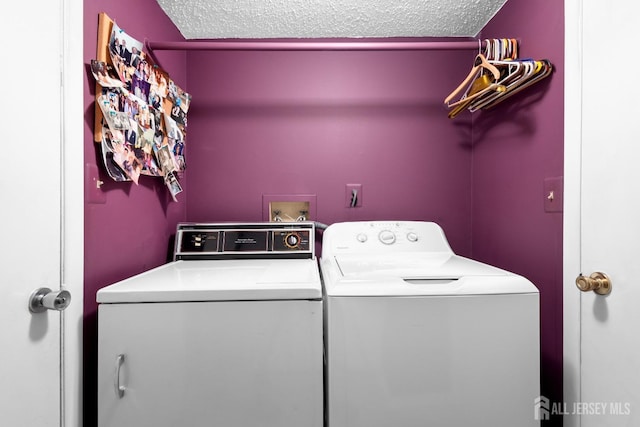 washroom featuring washer and clothes dryer and a textured ceiling