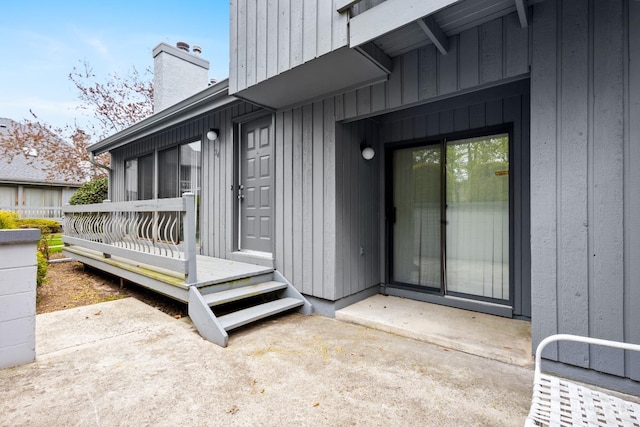 property entrance featuring a chimney and a deck