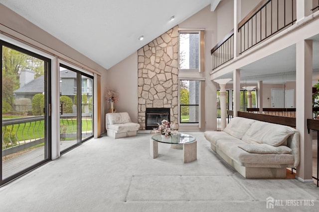 living room with plenty of natural light, carpet floors, high vaulted ceiling, and a fireplace