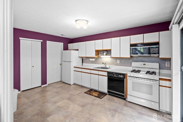kitchen featuring white appliances, a sink, light countertops, white cabinets, and a textured ceiling