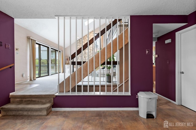 stairs featuring baseboards and a textured ceiling