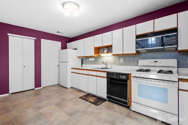 kitchen with black appliances, a sink, light countertops, and white cabinetry