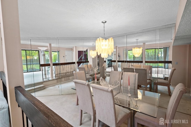 dining space featuring a chandelier, carpet floors, a textured ceiling, and plenty of natural light