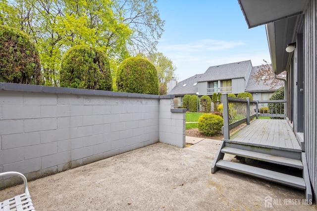 view of patio featuring fence and a wooden deck