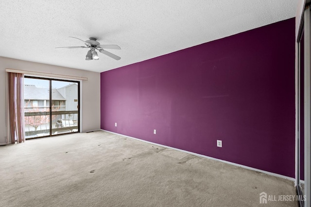 spare room featuring ceiling fan, carpet floors, a textured ceiling, and baseboards