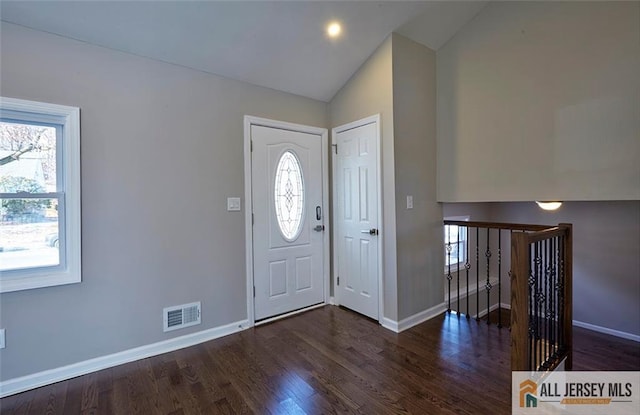 foyer with dark hardwood / wood-style floors, a wealth of natural light, and lofted ceiling