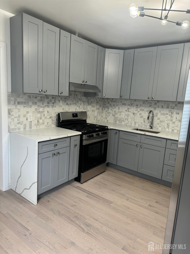 364 Myrtle St, Perth Amboy, NJ 08861 - kitchen featuring stainless steel gas range, gray cabinetry, light countertops, and decorative backsplash