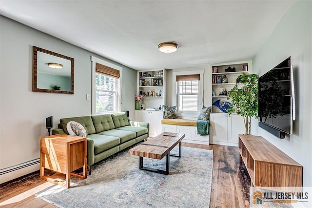 121 E Cliff Rd, Colonia, NJ 07067 - living area with wood finished floors, plenty of natural light, a baseboard heating unit, and built in shelves