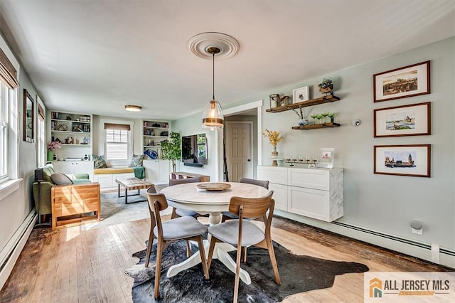 121 E Cliff Rd, Colonia, NJ 07067 - dining room featuring a baseboard heating unit and light wood-style flooring