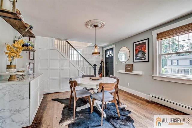 121 E Cliff Rd, Colonia, NJ 07067 - dining space with baseboard heating, stairs, and wood finished floors