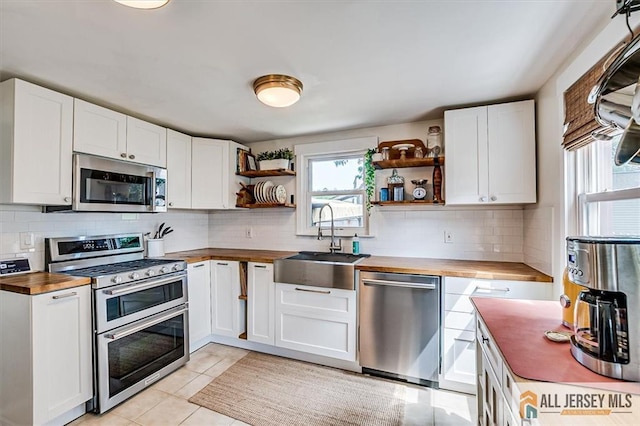 121 E Cliff Rd, Colonia, NJ 07067 - kitchen with butcher block counters, appliances with stainless steel finishes, open shelves, and white cabinetry
