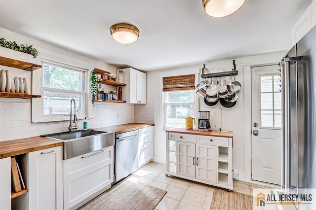 121 E Cliff Rd, Colonia, NJ 07067 - kitchen with butcher block countertops, open shelves, stainless steel appliances, light tile patterned flooring, and backsplash