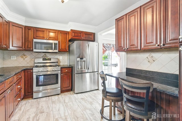 68 Pennsylvania Ave, Perth Amboy, NJ 08861 - kitchen with appliances with stainless steel finishes, decorative backsplash, dark stone countertops, and a kitchen bar