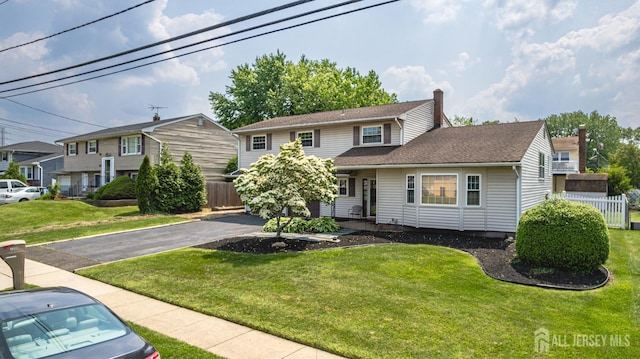 1208 Omaha Rd, North Brunswick, NJ 08902 - view of front of house with a chimney, asphalt driveway, and roof with shingles