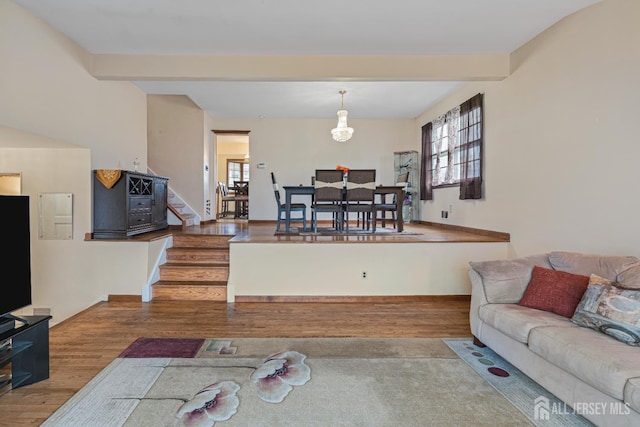 1208 Omaha Rd, North Brunswick, NJ 08902 - living area featuring wood finished floors, plenty of natural light, stairway, and beam ceiling