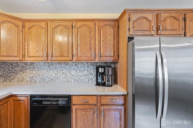 1208 Omaha Rd, North Brunswick, NJ 08902 - kitchen with freestanding refrigerator, black dishwasher, light countertops, tasteful backsplash, and brown cabinetry
