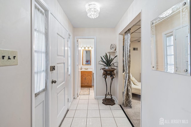 1208 Omaha Rd, North Brunswick, NJ 08902 - hallway with light tile patterned floors and a chandelier
