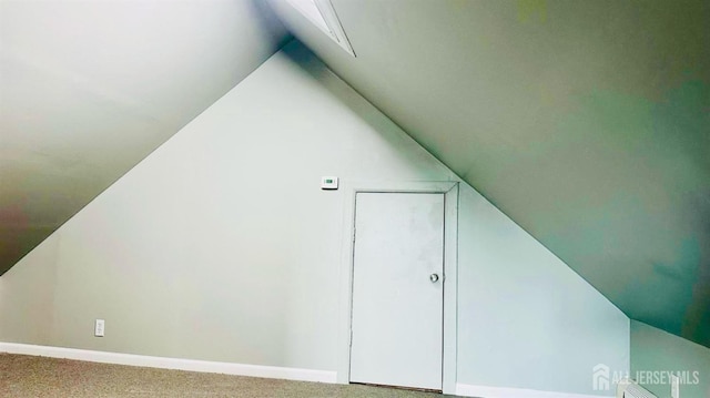 bonus room with baseboards, vaulted ceiling, and carpet floors