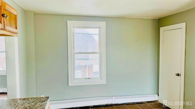 spare room with a baseboard heating unit and baseboards