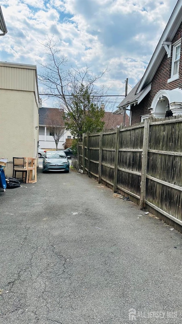 view of parking / parking lot with fence