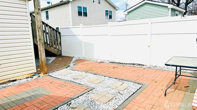 view of patio featuring fence and stairs
