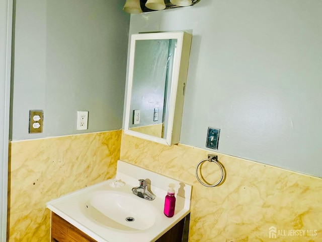 bathroom with vanity and tile walls