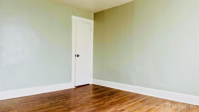 empty room with baseboards and wood finished floors