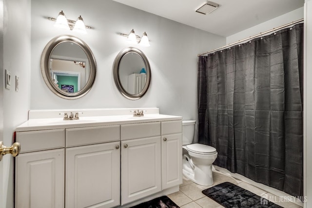 bathroom featuring vanity, tile patterned floors, and toilet