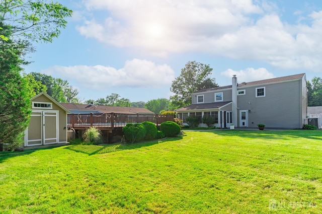 1682 Taylor Dr, North Brunswick, NJ 08902 - rear view of house with a storage unit, a wooden deck, a yard, and a chimney